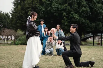 公園求婚現場，朋友在旁歡呼見證